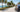 Senior rider on an electric tricycle on a sunny Florida coastal road with palm trees