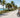Senior rider on an electric tricycle on a sunny Florida coastal road with palm trees